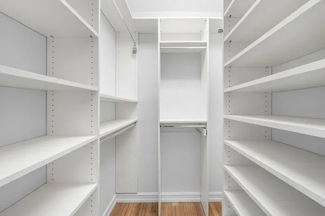 a view of walk in closet with empty racks