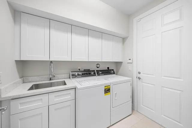 a tree in front of a brick house next to a yard