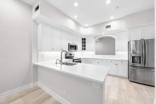 a kitchen with kitchen island a sink stainless steel appliances and cabinets