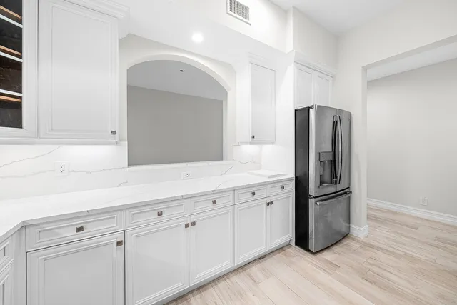 a kitchen with stainless steel appliances granite countertop a refrigerator and a sink