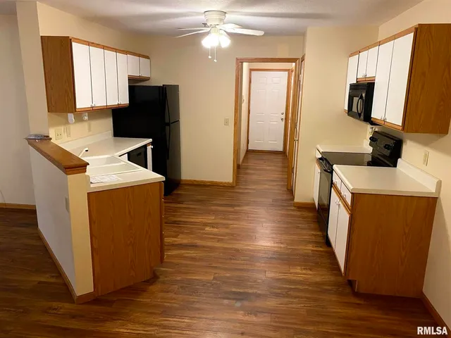 a kitchen with sink a refrigerator and wooden floor