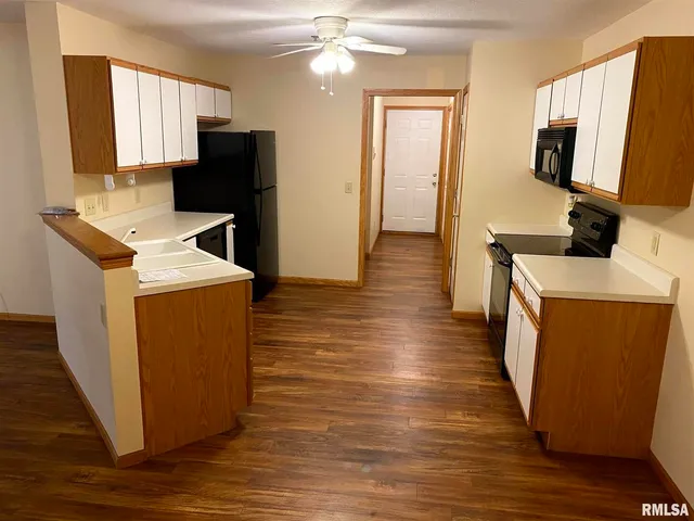 a kitchen with sink a refrigerator and wooden floor