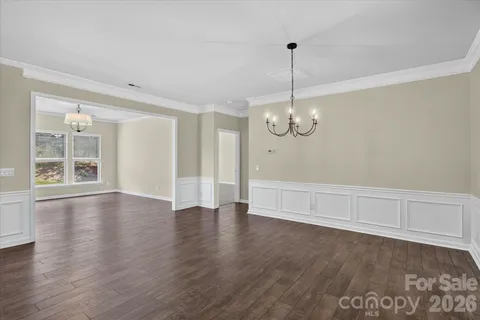 a view of a kitchen with a stove wooden floor kitchen view and a chandelier
