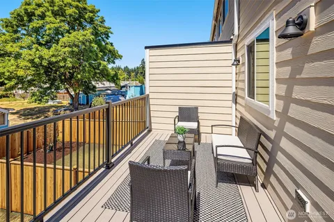a balcony with wooden floor and large trees
