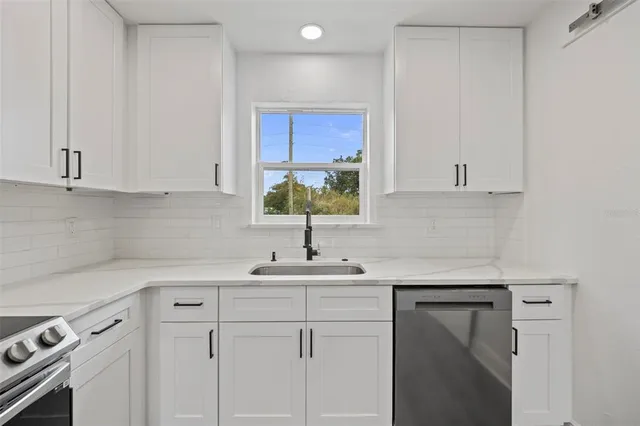 a kitchen with a sink cabinets and white appliances