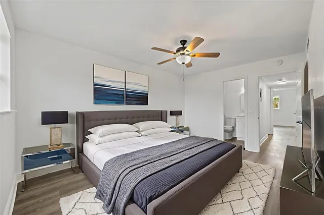 a bedroom with a bed a chandelier and a window