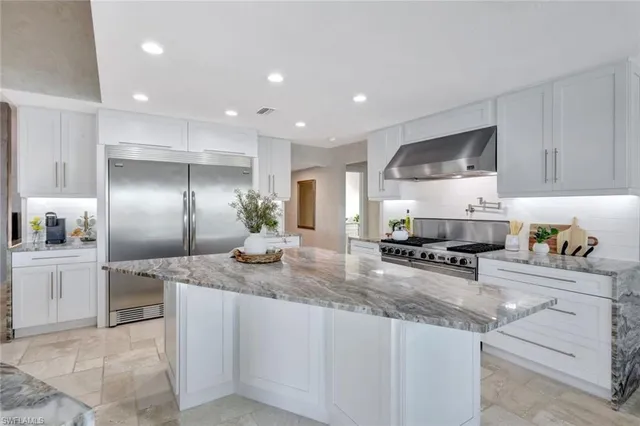 a kitchen with stainless steel appliances granite countertop a sink a stove and a refrigerator