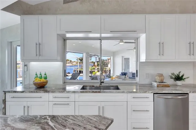 a kitchen with a sink a window cabinets and stainless steel appliances