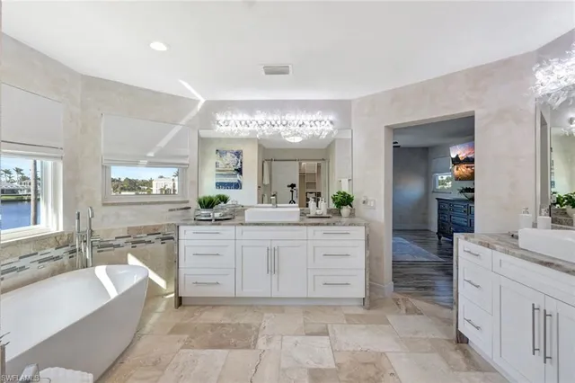 a large bathroom with a large tub sink vanity and granite