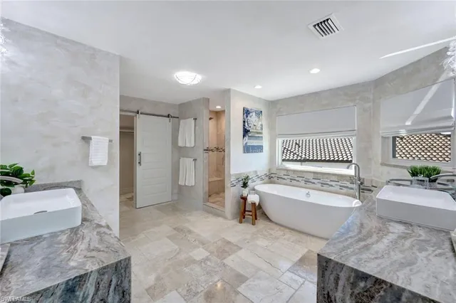 a spacious bathroom with a granite countertop tub sink and mirror