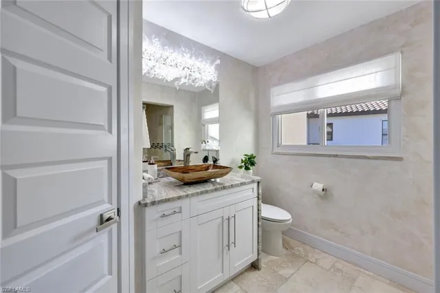 a bathroom with a granite countertop sink a toilet and a mirror