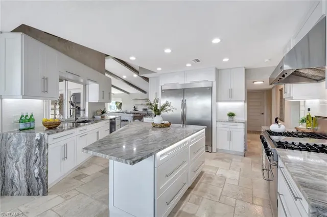 a large kitchen with stainless steel appliances kitchen island granite countertop a sink and cabinets