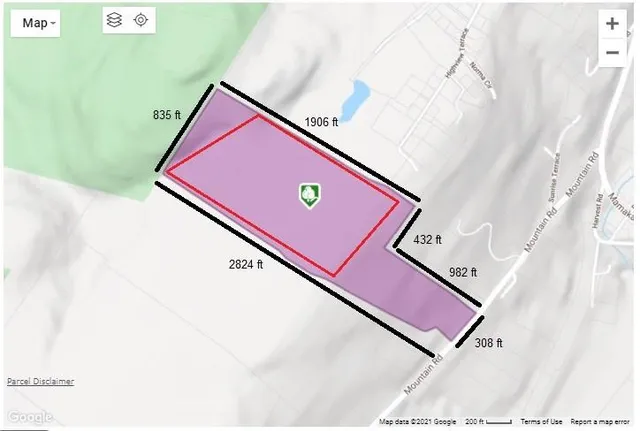 a view of a lush green forest with a house
