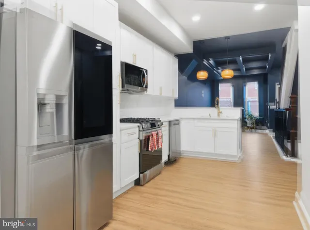 a kitchen with stainless steel appliances a stove top oven a sink and a refrigerator