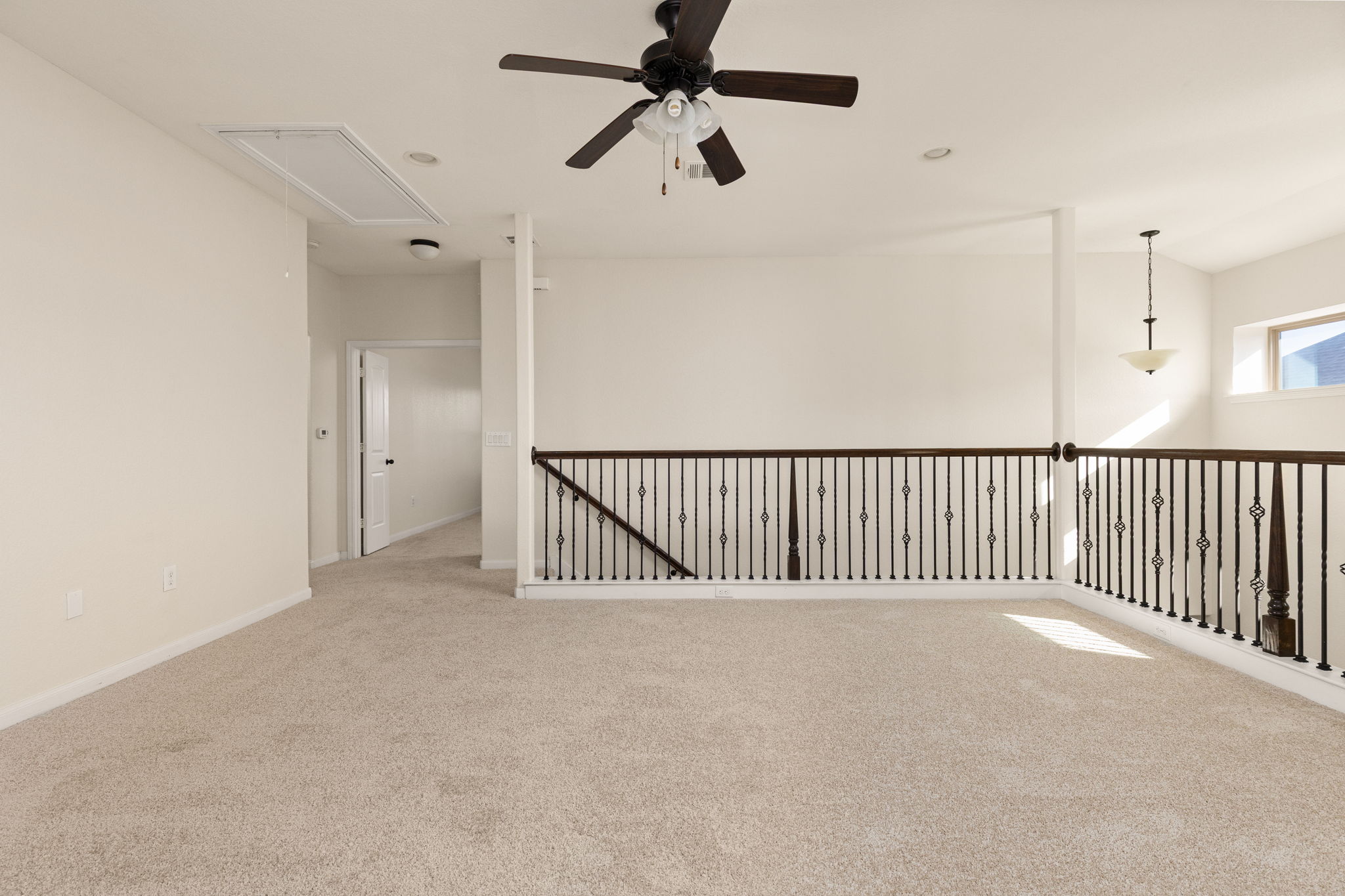 2400 Leonards Pass Leander, TX 78641 - Photo 23 of 40 A versatile open loft area provides additional living space with plush carpet and an elegant wrought iron railing.