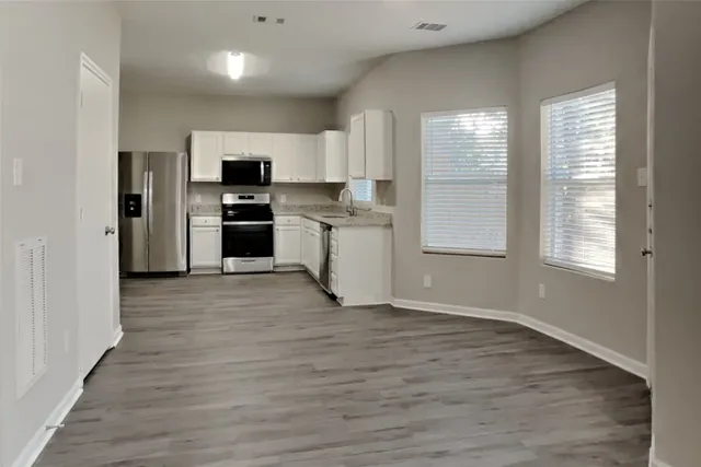a kitchen with a refrigerator and a stove top oven