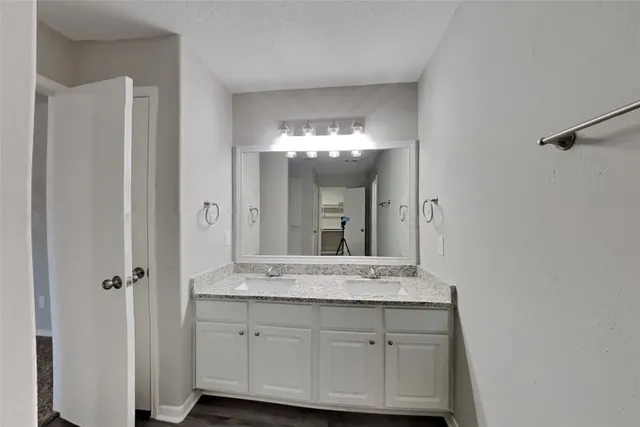 a bathroom with a granite countertop sink a mirror and a vanity
