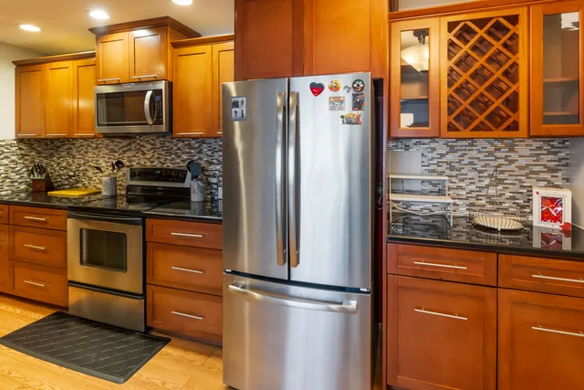 a kitchen with stainless steel appliances granite countertop a refrigerator and a sink