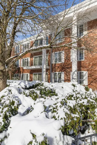 a view of a building with a yard covered in snow