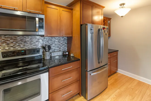 a kitchen with granite countertop a refrigerator stove and microwave