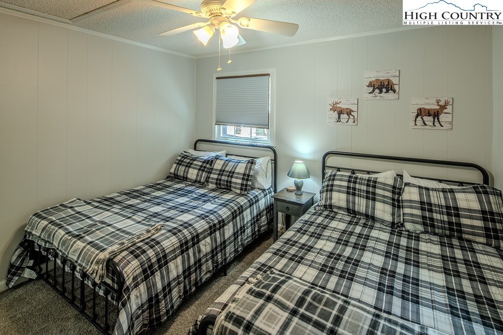 198 Black Pine Road Newland, NC 28657 - Photo 23 of 34 a bedroom with a bed and a chandelier