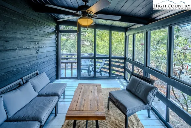 a living room with furniture and a floor to ceiling window