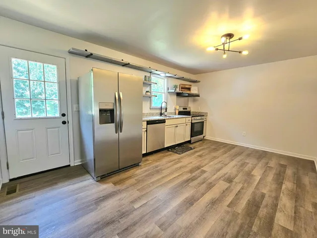 a kitchen with stainless steel appliances a refrigerator and a stove top oven