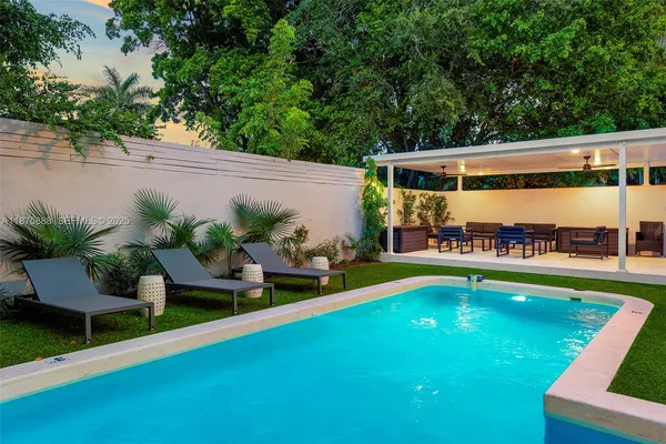 a view of an house with swimming pool and sitting area