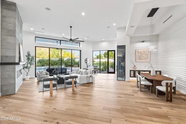 a view of a dining room and livingroom with lots of furniture wooden floor a chandelier
