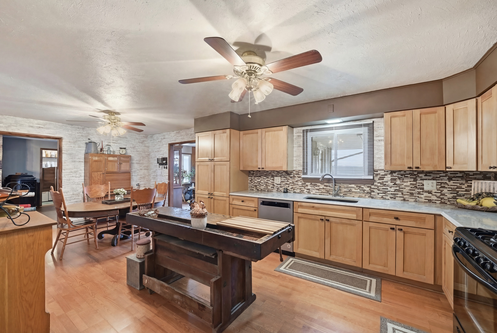 28007 Brickville Road Sycamore, IL 60178 - Photo 5 of 39 a kitchen with a stove a sink dishwasher and a dining table with wooden floor