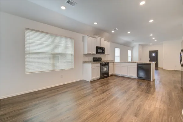a view of kitchen with wooden floor and electronic appliances