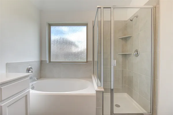 a white bath tub sitting next to a shower
