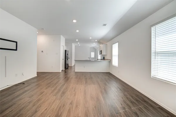 a view of a big room with wooden floor and windows
