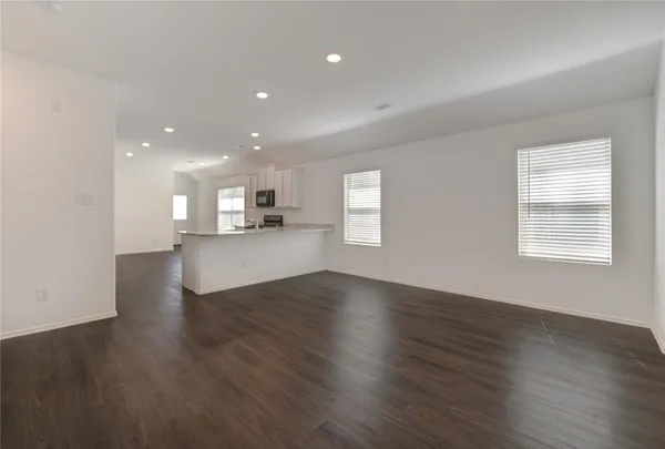 a view of a kitchen with wooden floor and a window