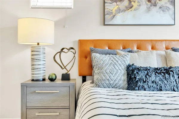 a bedroom with a bed and a painting on the wall