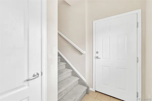 a view of staircase with white walls and white door