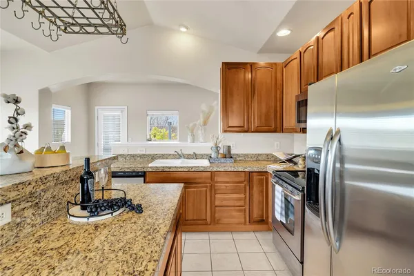 a kitchen with stainless steel appliances granite countertop a sink stove and refrigerator