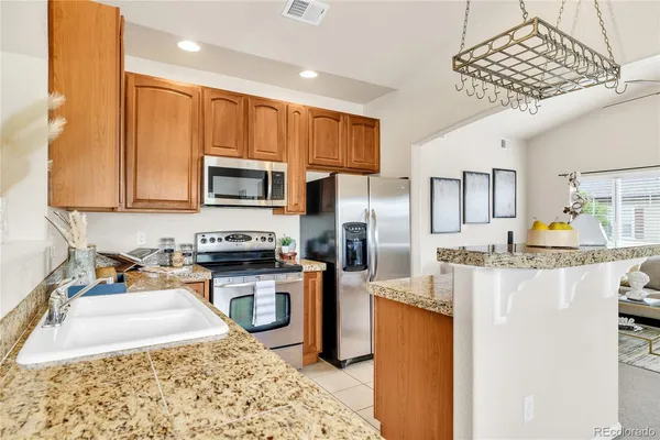 a kitchen with stainless steel appliances granite countertop a stove refrigerator sink and microwave