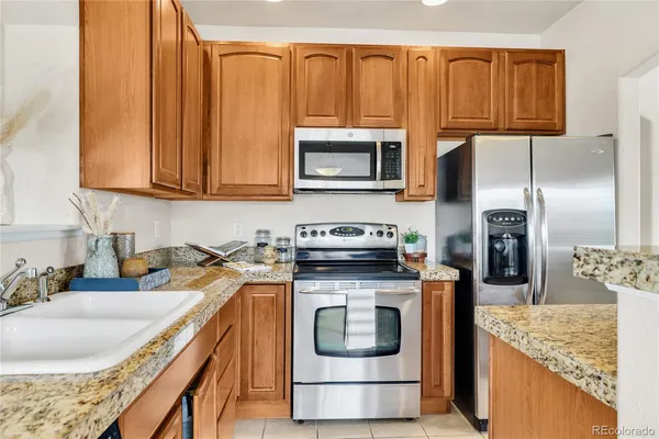 a kitchen with stainless steel appliances granite countertop a stove a sink and a microwave