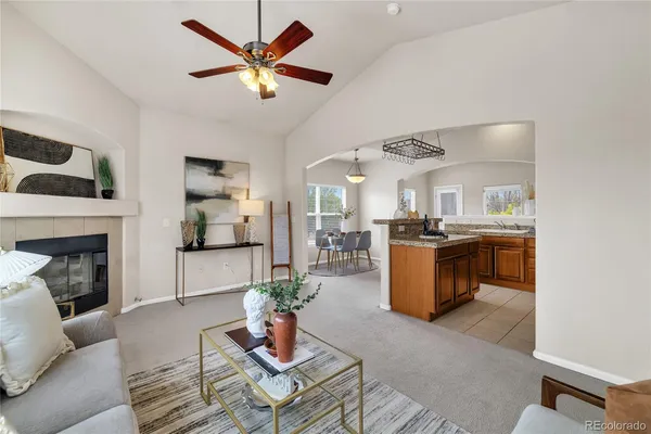 a living room with furniture kitchen view and a fireplace