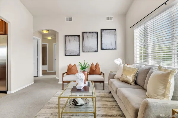 a living room with furniture a rug and a window