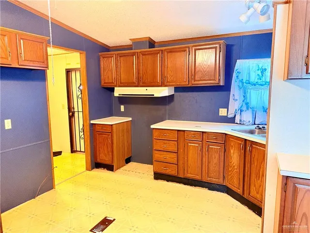 a kitchen with stainless steel appliances granite countertop a refrigerator a sink dishwasher and wooden cabinets