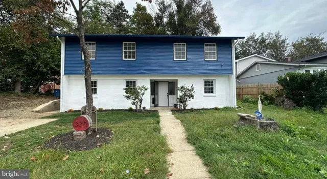 a white toilet sitting next to a bathroom sink and a mirror