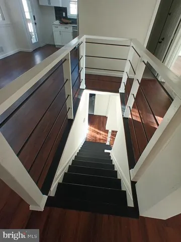a view of wooden floor in a hall with an entryway