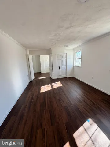 a kitchen with granite countertop white cabinets and a wooden floor