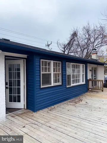 a backyard of a house with wooden floor and outdoor seating