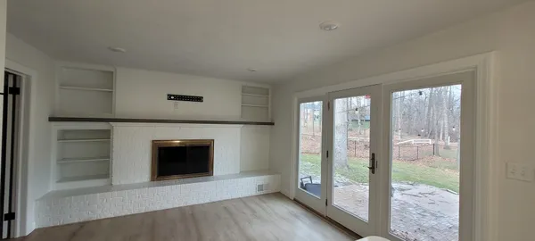 a view of an empty room with glass door and a window