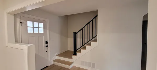a view of entryway with wooden floor and stairs