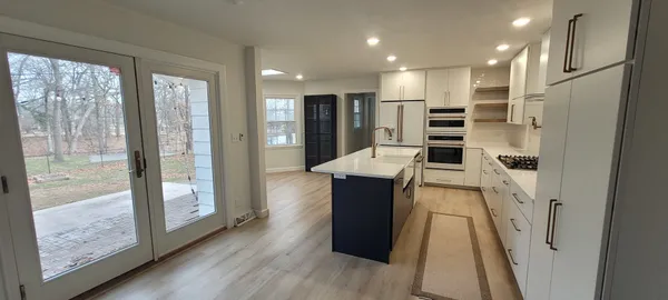 a kitchen with stainless steel appliances kitchen island granite countertop a refrigerator and a stove top oven