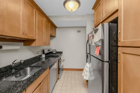 a kitchen with stainless steel appliances granite countertop a refrigerator and a sink